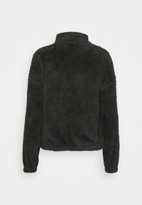 Sudadera de felpa negra y suave con cuello alto y mangas largas, que presenta una textura blanda y un dobladillo elástico. Se muestra la vista trasera.