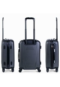 Maleta rígida negra con mango extensible, cuatro ruedas, cierre de cremallera y superficie texturizada. Cuenta con un asa lateral y surcos en la parte superior.