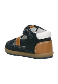 Sandał zamknięty dla malucha, z czarnego zamszu, z brązowymi i białymi skórzanymi akcentami, pasek na rzep oraz gumowa podeszwa, widok z tyłu pod kątem.