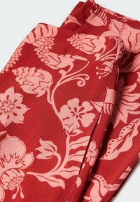 Roter Stoff mit floralem Muster in Hellrosa, der komplizierte Blumen und blättrige Designs zeigt. Weiche Textur, glatte Oberfläche.