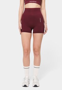 Pantalones cortos atléticos de talle alto en color burdeos, confeccionados en material elástico, con un diseño ajustado y un discreto logo de la marca en el lateral.