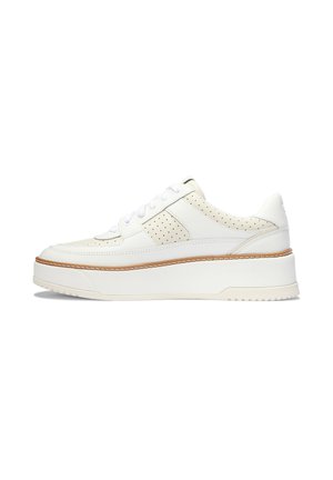 Hvide lav-top sneakers med perforerede sidelapper, hvide snørebånd og en tyk hvid sål med tan syninger.