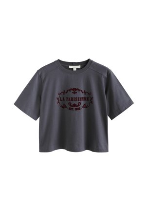Graues, kurzärmliges, cropped T-Shirt aus Baumwolle mit rundem Halsausschnitt, das ein burgunderrotes Druckdesign mit dem Text "LA PARISIENNE EST. 1982." zeigt.