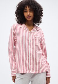 Ροζ και λευκό ριγέ φανελένιο πυτζάμα τοπ με μακριά μανίκια, γιακά, μπροστινή τσέπη και κλείσιμο με κουμπιά. Απαλή υφή, άνετη εφαρμογή.