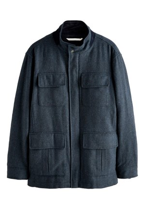 Veste en laine bleu foncé avec col montant, quatre poches avant à rabat, et une fermeture éclair dissimulée à l'avant avec bouton-pression.
