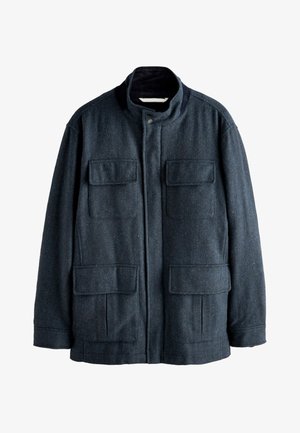 Giacca di lana blu scuro con colletto alla coreana, quattro tasche anteriori con pattina e chiusura frontale con zip nascosta e bottone a pressione.