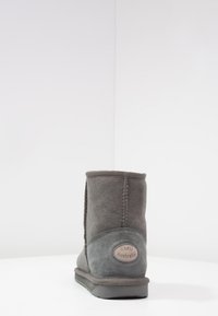 Stivale alla caviglia in suede grigio con texture morbida, punta arrotondata, dettagli cuciti e suola in gomma. Etichetta del marchio sul retro.
