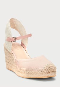 Sandalové espadrilky na klínu v světle růžové plátno s tkaným přírodním vláknem na kotníku. Mají zaoblenou špičku, patu omotanou jutou a jemné logo.