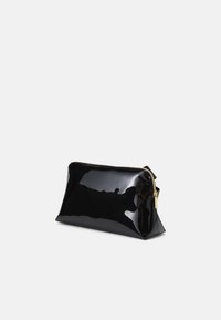 Bolso de mano de charol negro con forma triangular, cremallera dorada y acabado brillante y elegante. Diseño compacto adecuado para lo esencial.