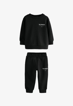 Crna dukserica dugih rukava i trenirka s bijelim natpisom "ALLSAINTS LONDON" i japanskim znakovima na oba komada.