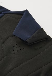 Svart textil med en slät, matt yta, med en marinblå tygvikning och små perforeringar för ventilation.