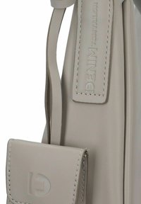 Borsa in pelle beige con una texture liscia, dotata di una tracolla e di una piccola tasca frontale. Logo stampato sulla tracolla.