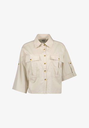 Beige cropped shirt met een gestructureerde kraag, twee borstzakken en korte mouwen. Voorzien van gele knopen en een gladde, lichte stof.