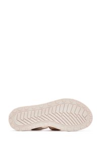 Suola delle scarpe con un motivo a battistrada testurizzato, caratterizzata da un colore crema chiaro e da una serie di lugs esagonali per la trazione; design piatto senza marcature visibili.