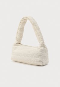 Bolso de tela acolchada color crema con una correa única acolchada y un sutil patrón de texto cosido en la superficie, exhibido sobre fondo blanco.