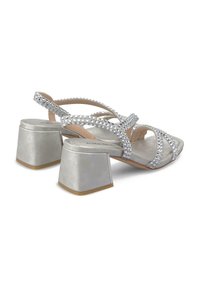 Sandalias de tacón bloque plateadas con tiras entrelazadas adornadas con strass. Presentan una textura suave y un acabado semisio.