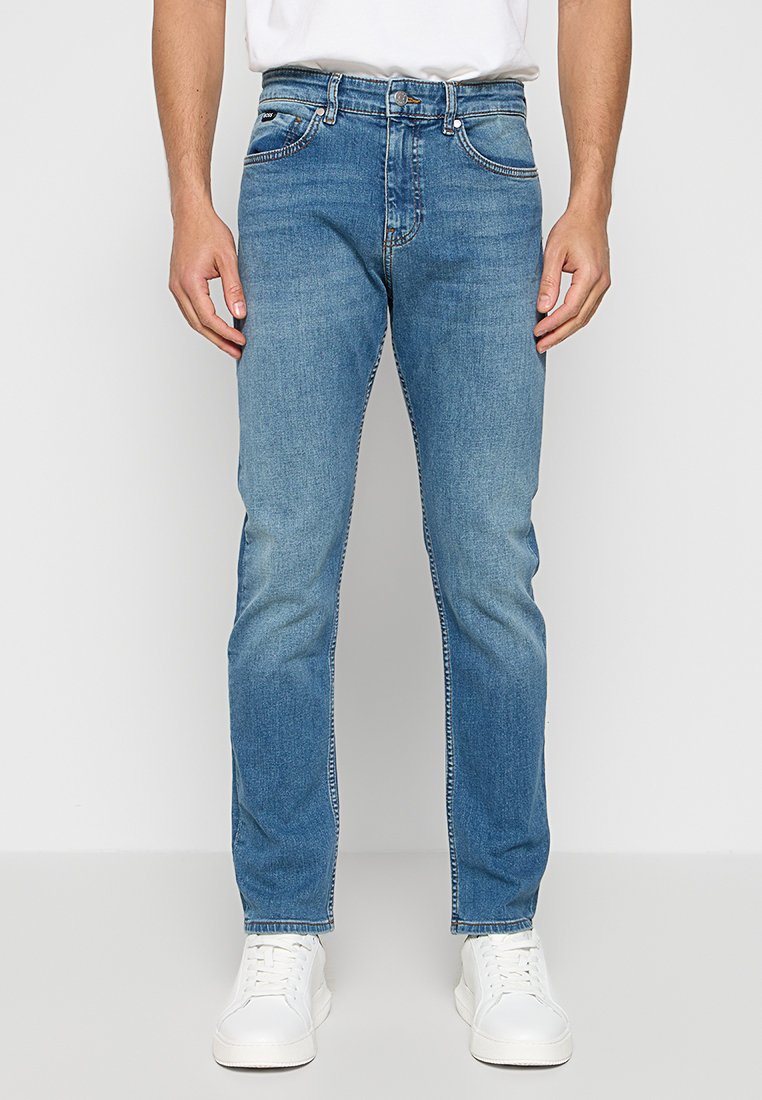 Jeans en denim bleu clair avec une coupe droite, cinq poches et un léger délavage. Fini avec un bouton standard et une fermeture éclair.