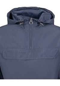 Giacca a vento blu navy con cappuccio, chiusura frontale a metà zip e tasca con patta. Texture liscia con cordoncino regolabile e dettagli in metallo.