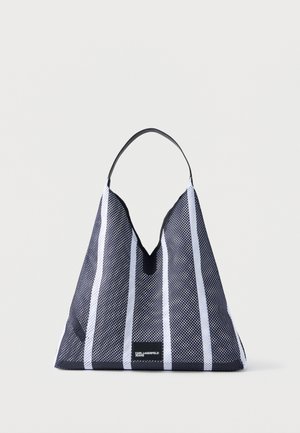 Czarna i biała torba typu tote z siatki w paski, z jednym czarnym uchwytem oraz małą metką "Karl Lagerfeld Jeans" umieszczoną pośrodku na dole.