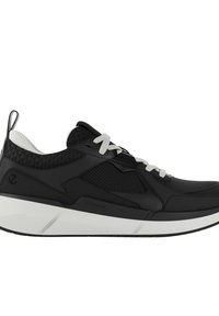 Svart idrottssko med en strukturerad ovandel, vita snören och en tjock vit sula. Har mesh-accenter och en förstärkt hälflik.