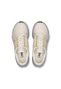 Zapatillas deportivas blancas con parte superior texturizada y suela gris claro. Presentan cordones amarillos, puntera reforzada y logotipo en la lengüeta.