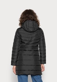 Svart puffjacka med huva, med en cinchad midja och horisontella quiltade sektioner. Slät textur och medellång design.