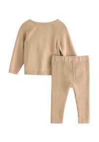 Beżowy sweter dziany z długimi rękawami i prążkowanymi spodniami. Miękka tekstura, prosty design, okrągły dekolt oraz prążkowane mankiety na obu elementach.