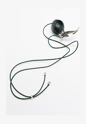 Sort vedhæng på en mørk snor med sølvdetaljer og en bladformet charm på en hvid baggrund.