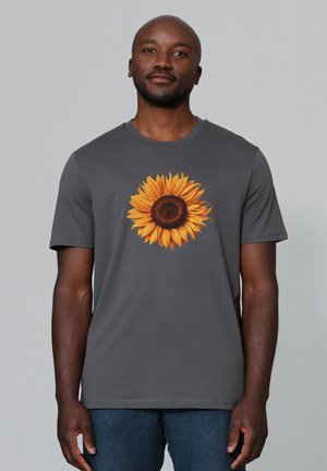 T-shirt en coton gris avec un graphique de tournesol vibrant sur le devant. Manches courtes et design à col ras du cou.