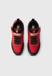 Κόκκινα αθλητικά παπούτσια με μαύρες λεπτομέρειες, επάνω μέρος από υφασμάτινο υλικό με υφή, σχέδια στις λουρίδες, μαύρα κορδόνια και λευκή σόλα. Φέρουν το λογότυπο "Skechers".