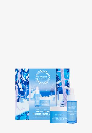 Coffret de soins Lumene comprenant un pot bleu clair et un flacon avec pipette, tous deux en verre dépoli, présentés dans une boîte illustrée vibrante bleue et blanche.