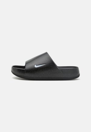 Sandale à glissière noire avec semelle et sangle texturées, présentant un petit logo Nike swoosh blanc sur le côté.