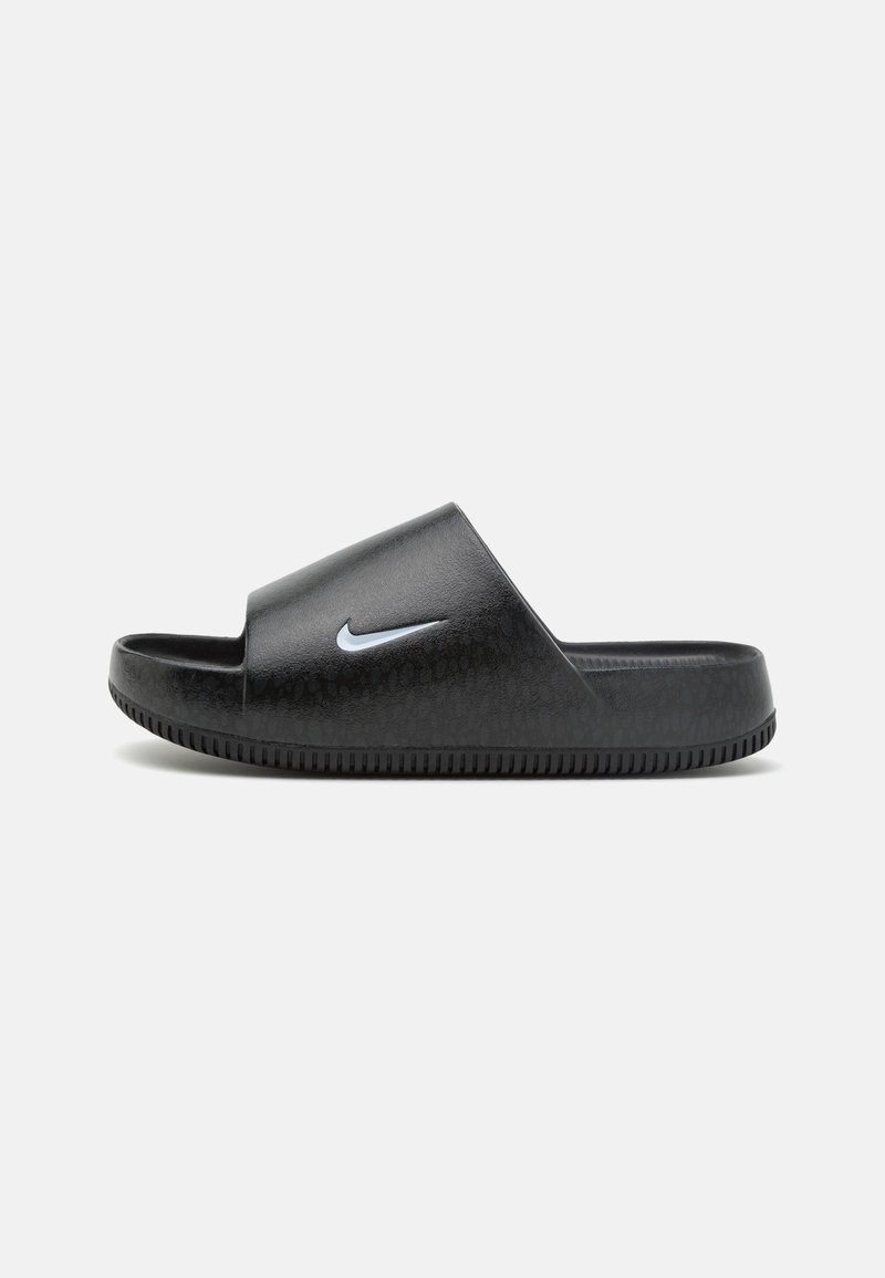 Sandalia negra con suela y tira texturizadas, con un pequeño logo blanco de Nike en forma de 'swoosh' en el lateral.