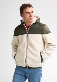 Fleece-gevoerde jack met een crèmige body en olijfgroene schouders, met een ritssluiting, zakken en een capuchon met verstelbare koorden.