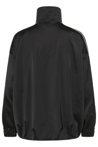 Chaqueta de satén negra con un alto cuello, puños elásticos y dobladillo inferior fruncido. Presenta rayas blancas a lo largo de los hombros. No se aprecian detalles frontales.