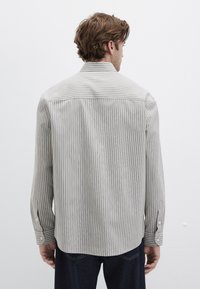 Gestreiftes Langarmshirt in Hellgrau und Weiß, aus weichem Stoff gefertigt. Verfügt über Manschetten mit Knöpfen und einen abgerundeten Saum. Minimalistisches Design.