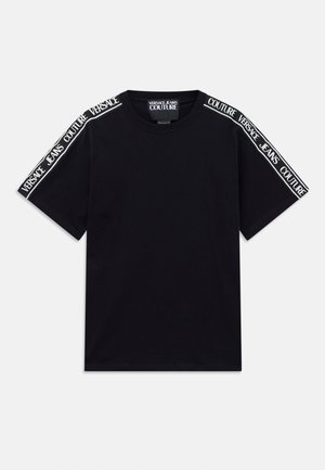 Sort kortærmet T-shirt med hvide "Versace Jeans Couture" tekstbånd, der løber langs skuldrene og den øverste del af ærmerne.