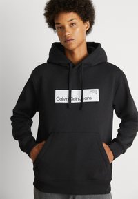 Calvin Klein Jeans HYPER REAL BOX LOGO GENDERLESS UNISEX - Jersey con capucha - black