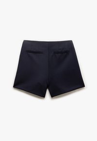 Pantaloni corti navy su misura con parte anteriore piatta, doppie tasche posteriori e linee nette. Realizzati in tessuto morbido, progettati per una vestibilità strutturata.