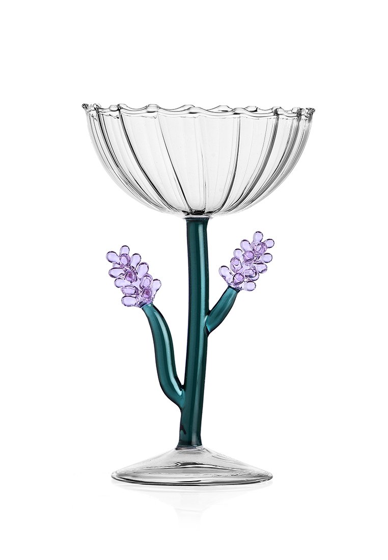 Przezroczysta szklana miska z falistym brzegiem, zielonym trzonkiem i dwoma fioletowymi kwiatowymi akcentami. Podstawa jest okrągła, z motywami kwiatowymi.