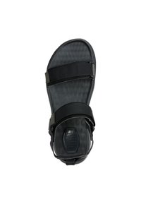 Sandales noires avec des brides en synthétique, semelle texturée et fermetures velcro réglables. Présente une forme galbée pour le confort.