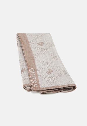 Foldet beige og lysebrunt håndklæde med diamantmønster, små logoer og teksten "GUESS" langs den ene kant.