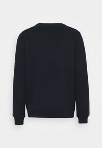 Felpa trapuntata navy con scollo rotondo, polsini e orlo a costine, caratterizzata da un motivo a diamante testurizzato su tutta la superficie.