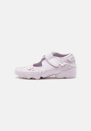 Jasnoróżowy sneaker z paskiem na rzep, kwiatowymi zdobieniami i miękką podeszwą, zaprojektowany do noszenia na co dzień i komfortu.
