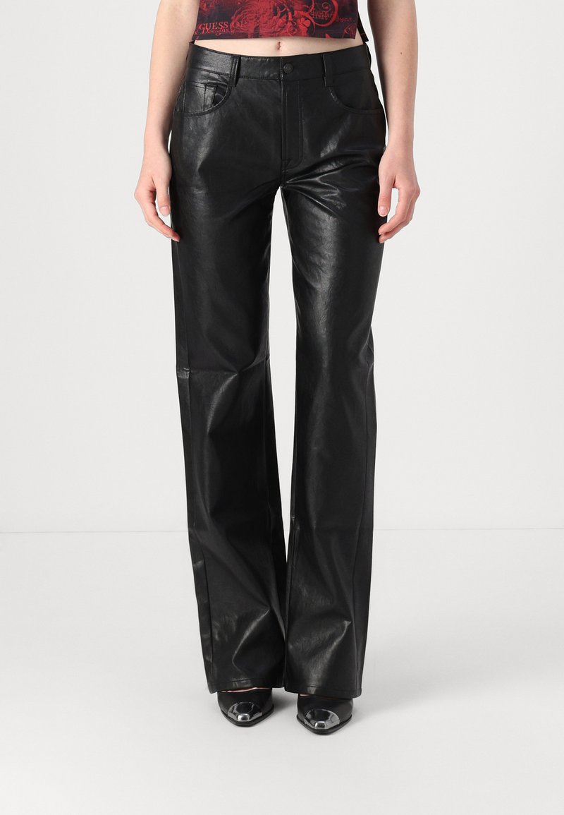 Black leather flared pants with a smooth texture, featuring front pockets and a button closure. Worn with black heeled shoes.