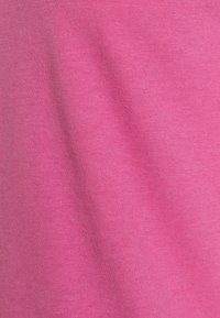 Růžová bavlněná látka s hladkou texturou, vykazující jemný elastický efekt a konzistentní vzor tkaní. Vhodná pro oděvy nebo doplňky.