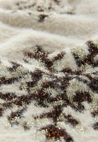 Fuzzy cream fabric with black, copper, and silver metallic threads forming a textured pattern. Soft and voluminous with varied sheen.