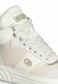 Sneaker alta in crema e bianco, con colletto in pelliccia sintetica, accenti in suede e pelle liscia, chiusura con lacci e dettagli con logo gioiello.