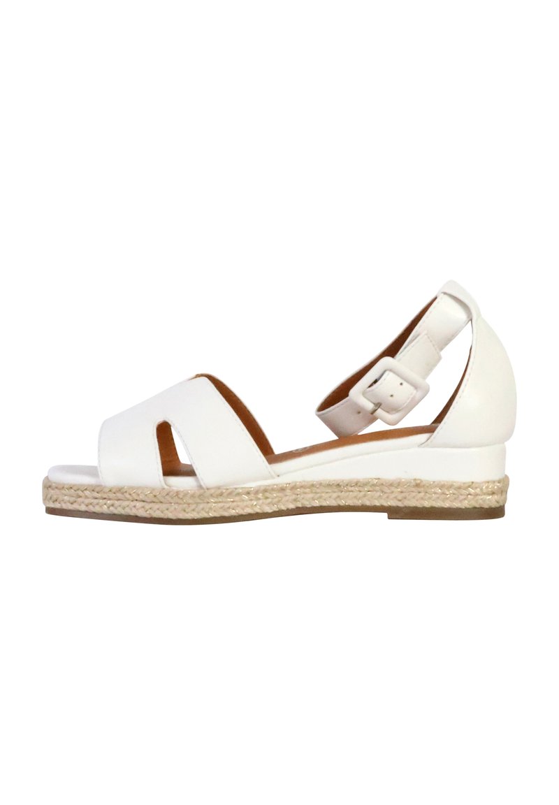 Sandales compensées blanches avec un design découpé, semelle intermédiaire en jute tressé et bride de cheville ajustable. Tige en cuir lisse et semelle plate.
