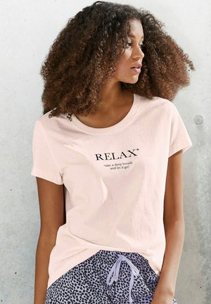 Light pink cotton t-shirt with short sleeves featuring "RELAX*" text and a motivational phrase. Paired with loose, patterned shorts.